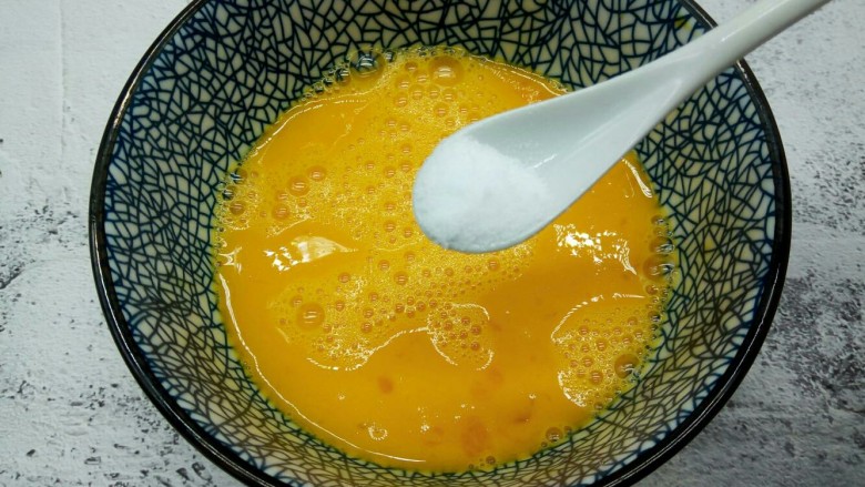 营养早餐【沙葱蒸饺】,用筷子顺时针把鸡蛋液打散，加半勺盐
