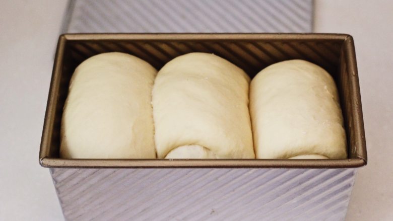 波兰酵种吐司,发到9分满的时候取出吐司盒，烤箱180度预热。取出的面团上面要用保鲜膜防止风干。
