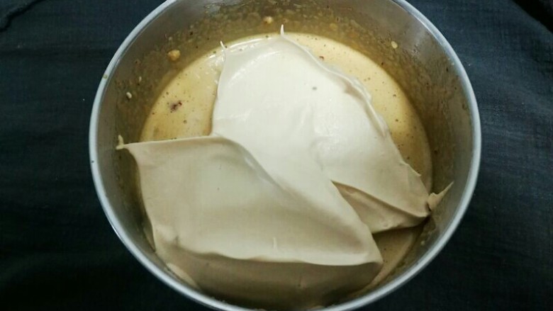 枣糕,把打发好的蛋白霜分次加入蛋黄糊中进行翻拌。