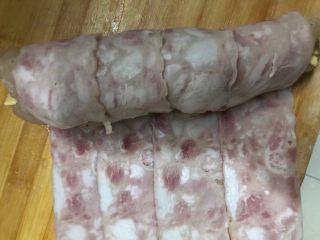培根芝士鸡肉卷,4.在用培根把鸡肉裹起来，包上一层保鲜膜，捆上几道线绳卷紧，放入冰箱冷藏一小时入味。