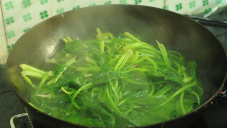 姜汁菠菜,菠菜放在开水中，汆烫一下