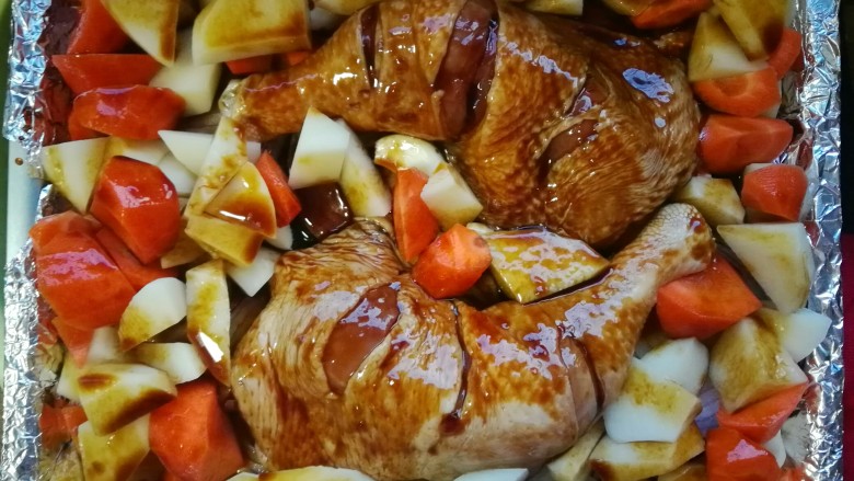 烤鸡腿（烤箱版）,蒜放在鸡腿周围，可以多放一些，土豆和胡萝卜放在鸡腿周围，不要放在鸡腿上，这样鸡腿皮会烤得脆脆的，你最后会明白多好吃的😊，剩下的腌料多铺一些在菜上。