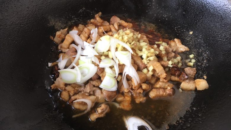#菌类料理# 黑木耳肉丁蚕豆酥,放入葱花和姜末，再次翻炒均匀。
