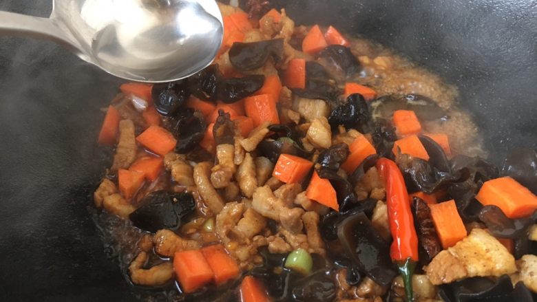 #菌类料理# 黑木耳肉丁蚕豆酥,放入50ml的开水，大火，将所有食材翻炒均匀，将胡萝卜炒至8成熟。
