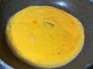 韭苔炒鸡蛋,慢慢晃动锅，摊成一张圆的鸡蛋皮，锅小的可以分两次来摊。