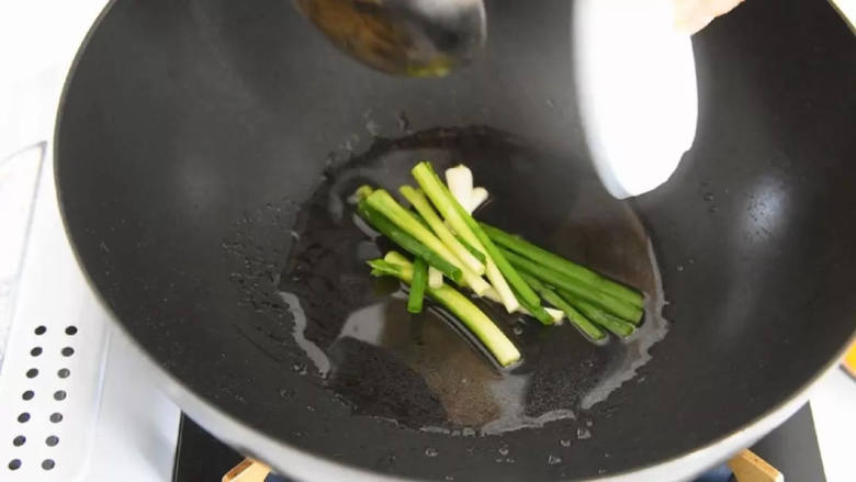 清脆爽口、简单易学的葱油南瓜,热锅冷油，下葱段爆香。