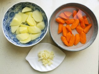 西红柿土豆炖牛腩,蒜切成蒜未，土豆和胡萝卜去皮后切成滚刀块，然后泡在水中备用。