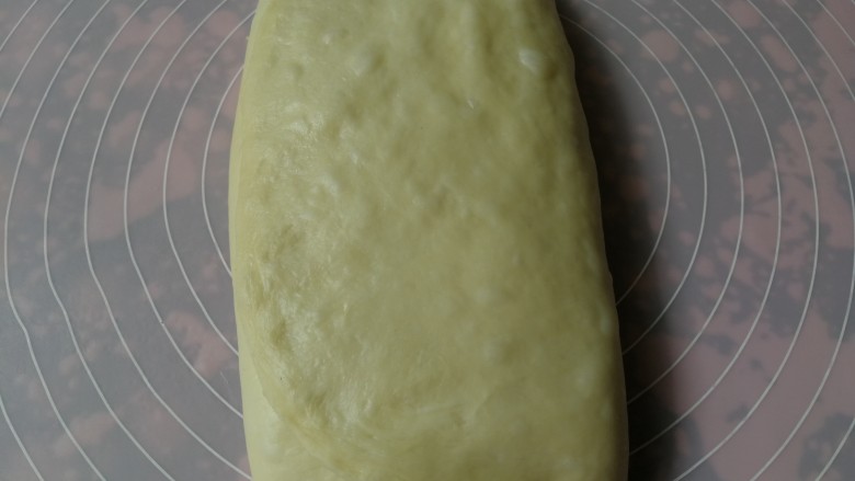 手撕椰蓉面包,将未铺椰蓉馅的1/3部分向中间折叠，然后右侧1/3再向内折叠盖上，呈三层面团两层馅料的状态