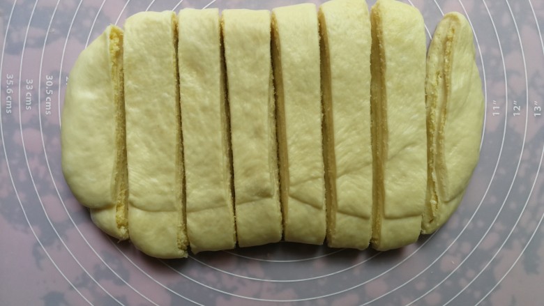 手撕椰蓉面包,二次三折后，再次擀开成长方形，用刀分割成均匀的八份
