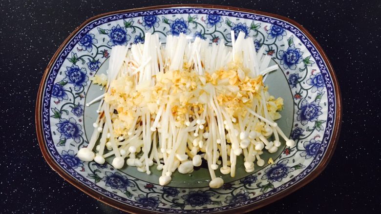 #菌类料理# 蒜蓉辣椒蒸金针菇,将步骤3炒好的蒜蓉放在金针菇的表面。