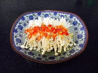 #菌类料理# 蒜蓉辣椒蒸金针菇,将小米椒圈撒在金针菇上。