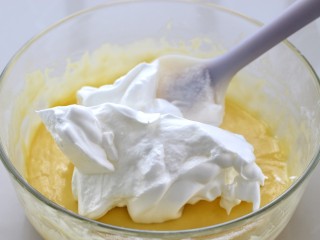 肉松小贝,取1/3的蛋白霜放入蛋黄糊中，用刮刀翻拌均匀，注意不要划圈搅拌