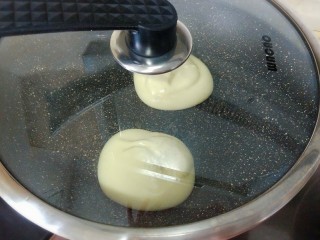 日式舒芙蕾厚松饼,不粘锅烧热，刷一层薄油，舀入一大勺松饼糊，小火煎制，盖上锅盖焖1-2分钟。