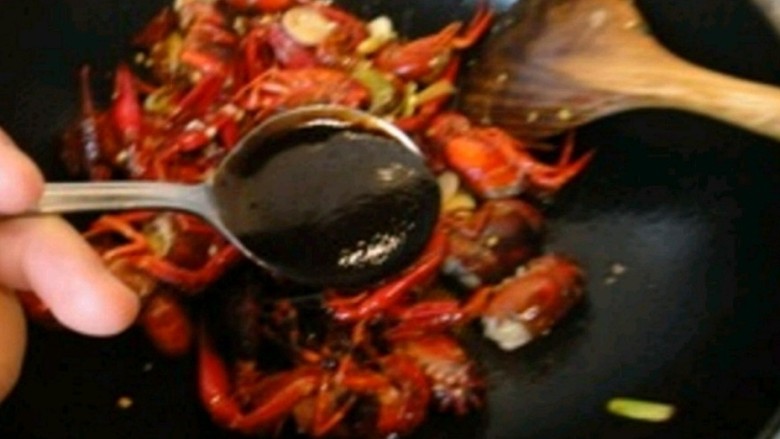孙氏麻辣小龙虾,至虾壳变红时，倒入一勺甜酱继续翻炒上色。