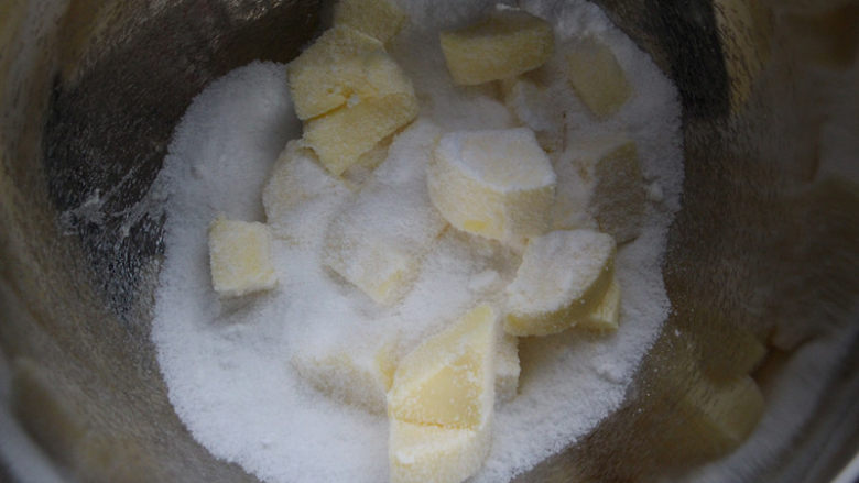 蔓越莓磅蛋糕,糖粉加入黄油，用打蛋器头压一下，防止打发的时候糖粉飞溅。