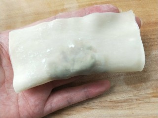 香煎槐花牛肉馄饨,馄饨皮上方用手指抹上一点水，对折捏紧。