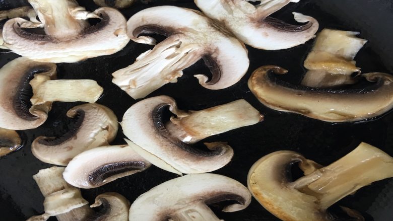 菌类料理+蘑菇手撕鸡胸肉,平底锅内刷少许植物油，将蘑菇片逐个放入，小火慢煎；