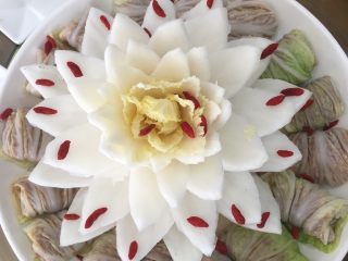 佛手观音,蒸箱蒸十分钟取出；把白菜茛雕刻成的花摆在中间；美味又好看的佛手观音完成