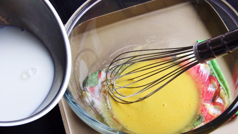 芒果慕斯蛋糕+6寸和4寸,用蛋抽搅拌均匀后，倒入加热后的牛奶，分几次加入。