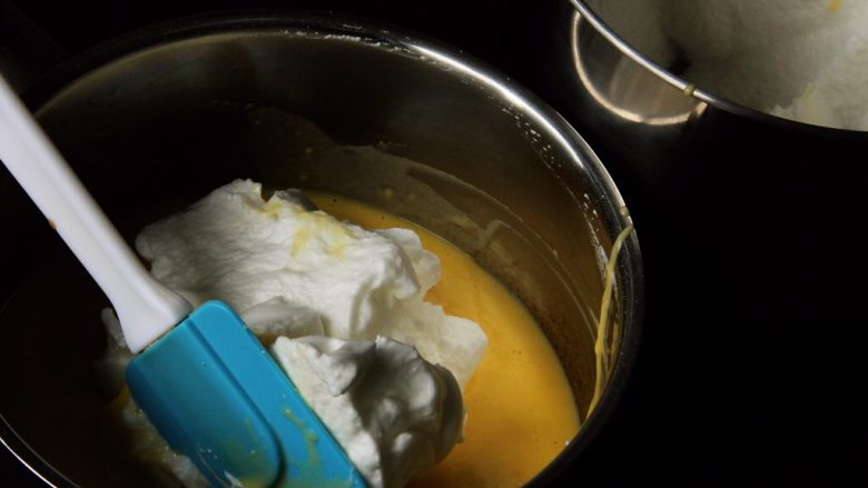 芒果慕斯蛋糕+6寸和4寸,取三分之一的蛋白霜进蛋黄中。