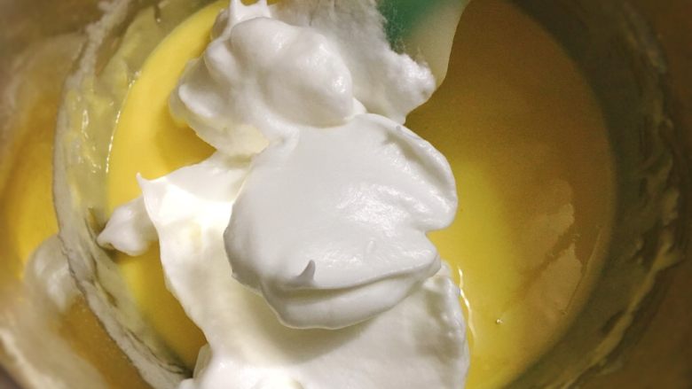 酸奶雪崩蛋糕 清爽不油腻,舀1/3蛋白进蛋黄酸奶糊，用切拌手法，拌均匀。