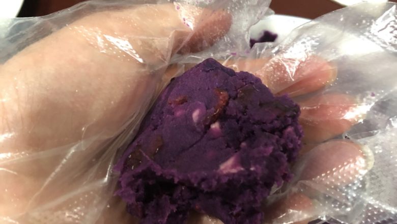 蔓越莓芝士紫薯球,套一次性手套，取一团蔓越莓紫薯泥搓圆。