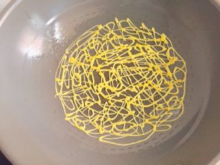 网格蛋饼,拿住裱花袋一边挤面糊，一边不规则的画圈，让每个圈圈都相连，形成网格状
