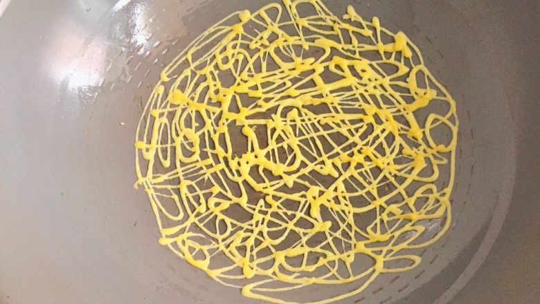 网格蛋饼,拿住裱花袋一边挤面糊，一边不规则的画圈，让每个圈圈都相连，形成网格状