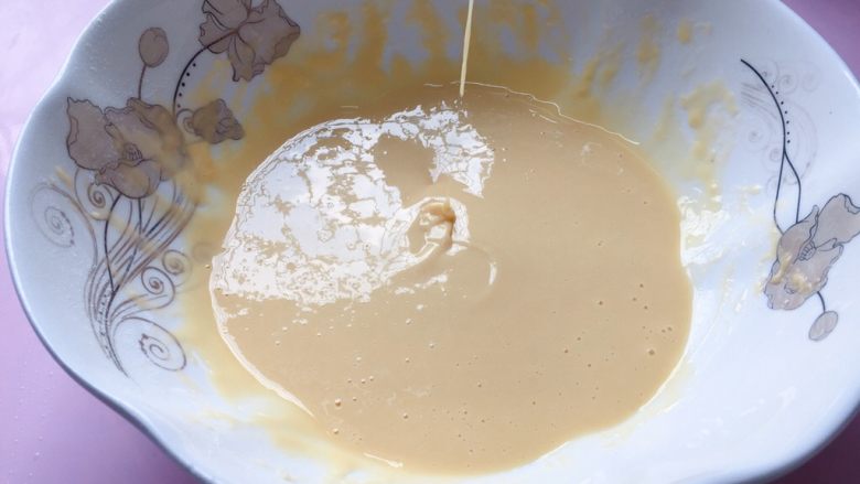 网格蛋饼,继续用手动打蛋器搅打，搅拌至面糊无颗粒状态，提起打蛋器，面糊呈流动状态即可