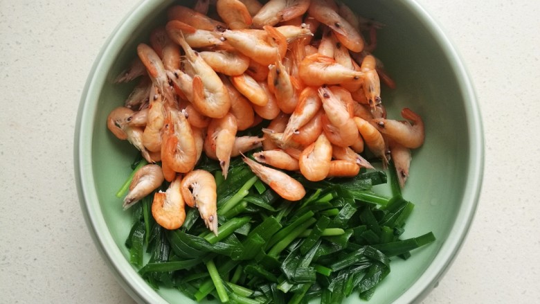 小白虾拌韭菜,把过凉后控干水份的小虾和韭菜放入容器中。