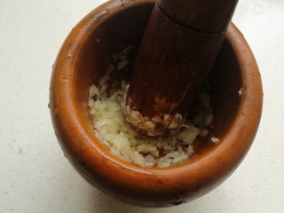 小白虾拌韭菜,把大蒜放入捣蒜器中捣成泥。