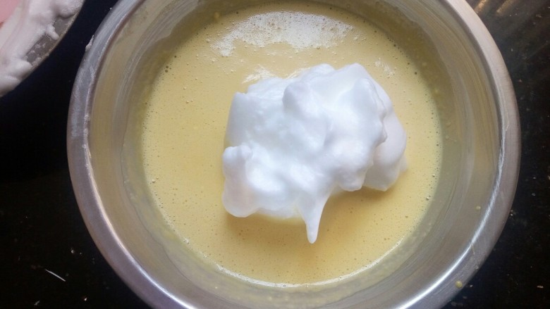 香葱肉松蛋糕,取1/3的蛋白霜放入到蛋黄糊中上下翻拌。


