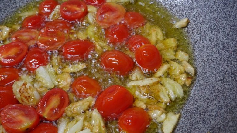 西西里鯷魚番茄義大利麵,待蒜頭香味出來後，將10粒對切的番茄下鍋拌炒，約1~2分鐘，下鍋時火可調大，再轉中小火。