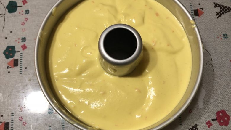 香橙戚风蛋糕,模具刷一层薄薄的油，将蛋黄糊倒入模具内，模具轻震几下。