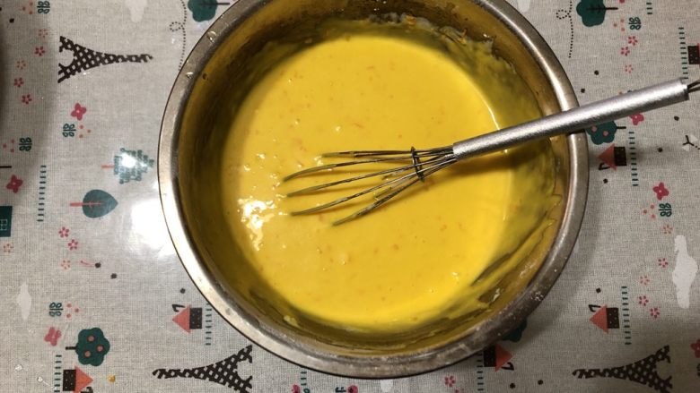 香橙戚风蛋糕,所有蛋黄一次性加入进去，用手动打蛋器画一字搅拌均匀。
再加入橙皮屑
如果有颗粒用刮刀按压即可。蛋黄糊放置一边备用。