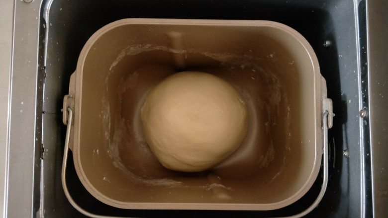 香葱芝士小餐包,收圆，放入桶中，盖保鲜膜进行第一次发酵。 

