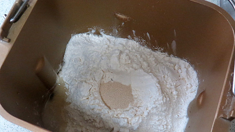 巴伐利亚碱水面包【普雷结】,面团材料除了黄油外，按先液体后粉类秩序放入面包机桶内，选择和面程序20分钟