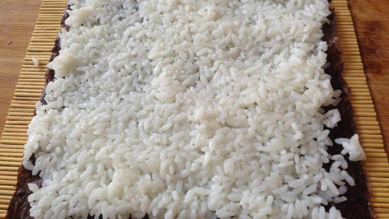 清甜玉米寿司,把米饭平铺在上面压实，注意尾部留出一点不要铺