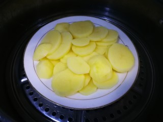 飘香土豆饼,切片的土豆，放蒸锅蒸熟
