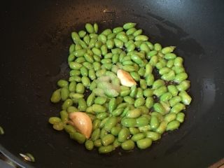 菌类料理+鸡枞菌炒豆子,放入豆子翻炒变色加1克盐。