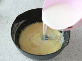 爆浆海盐奶盖蛋糕,牛奶加入奶锅中，煮至冒热气离火，
将热牛奶慢慢倒入面糊中一边倒一遍搅拌，混合均匀。