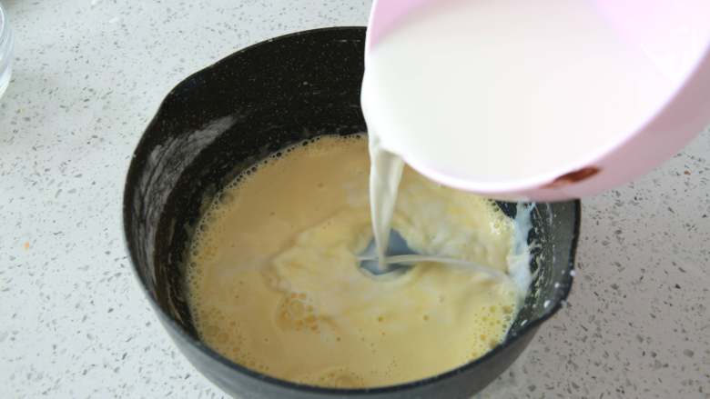 爆浆海盐奶盖蛋糕,牛奶加入奶锅中，煮至冒热气离火，
将热牛奶慢慢倒入面糊中一边倒一遍搅拌，混合均匀。