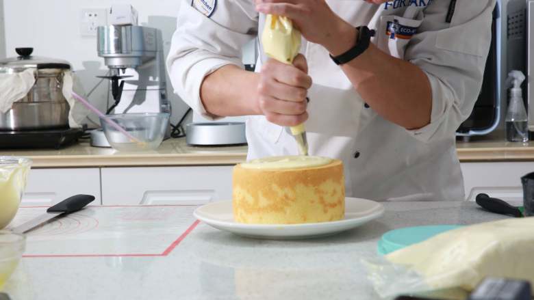 爆浆海盐奶盖蛋糕,表面的奶盖酱，用画圈圈的方式，最外一圈可以多挤一些，让奶盖酱自然流落下来。