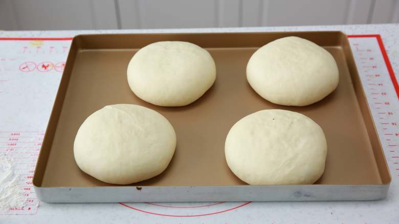 爆浆流心面包,放在烤盘上。每个面团之间要留有足够的空隙。继续在温暖湿润的环境下进行发酵至1.5-2倍大，手指轻摁表面可以缓慢回弹发酵完成。提前烤箱预热，上下火180度。