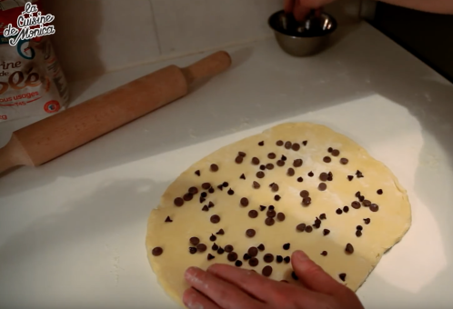 巧克力奶油小面包,加工制作 现在要加入巧克力块。 你们可以在揉完面之后就加入巧克力，这些小巧克力块也不会发酵所以制作加工前加入就可以。用擀面棒把面团擀一下。放一部分小巧克力块。使点劲儿把它们压进面团。对折几次再压成饼。加入剩下的巧克力，再对折几次擀压一下。 注意：留一些巧克力最后撒在面包上面。