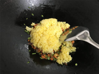 腊肠蛋炒饭,把拌上蛋液的米饭倒入锅中。
