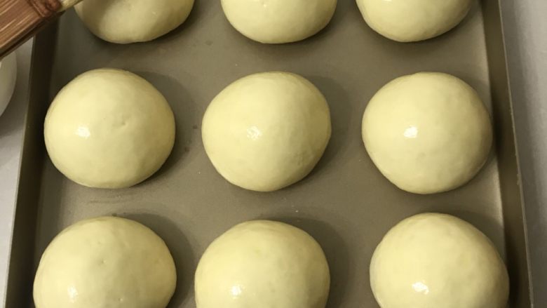 蛋黄豆沙小餐包,送进发酵箱，温度在35度左右，湿度保持在80％左右发酵一倍大，表面刷上全蛋液