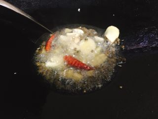 快手酸菜鱼 美味又开胃,加入蒜头爆香，
出香味后，加入姜片、泡椒、干辣椒、麻椒，小火煸香。