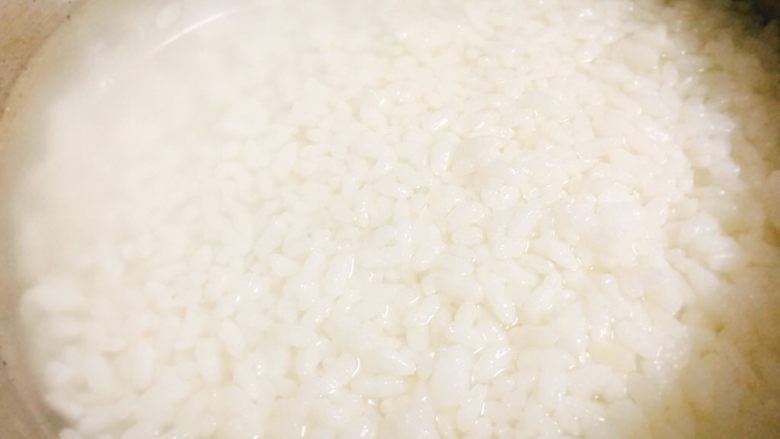 干贝鱿鱼白菜粥 鲜甜美味营养,加入少许水后，将米饭搅拌散开。
