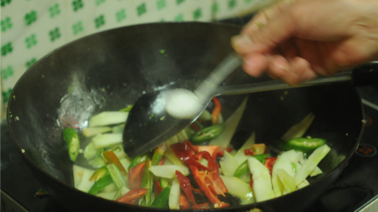 西兰花茎回锅肉,在辣椒片上撒点盐，翻炒两分钟至西兰花茎微微变软